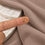 A gold hoop earring is being held up to a fabric surface.