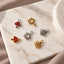 a collection of six charms, each with unique designs, arranged on a marble surface.